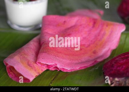 Rote-Bete-Ghee-Braten. Eine farbenfrohe, aromatische südindische knusprige Crapes aus fermentiertem Reis und Linsen gemischt mit Roter Bete. Serviert auf Ba Stockfoto