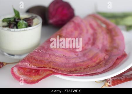 Rote-Bete-Ghee-Braten. Eine farbenfrohe, aromatische südindische knusprige Crapes, die mit einem fermentierten Teig aus Reis und Linsen gemischt mit Paste aus Roter Bete hergestellt werden. S Stockfoto