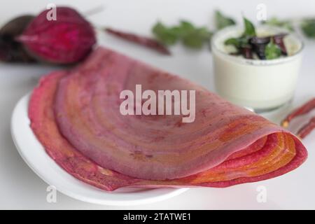 Rote-Bete-Ghee-Braten. Eine farbenfrohe, aromatische südindische knusprige Crapes, die mit einem fermentierten Teig aus Reis und Linsen gemischt mit Paste aus Roter Bete hergestellt werden. S Stockfoto