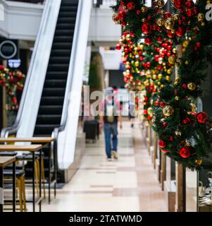 Weihnachtsdekoration im Einkaufszentrum. Nicht erkennbare Leute, die durch die Geschäfte laufen. Auckland. Neuseeland. Stockfoto