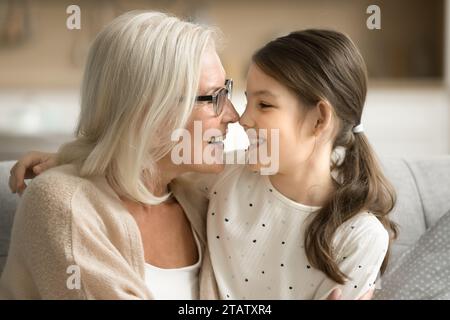 Glückliche Seniorengroßmutter und süßer Enkel, der sich umarmt, lacht und Freizeit genießt Stockfoto