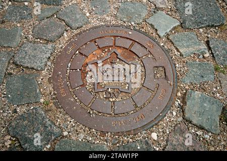 Mannlochabdeckung auf dem Boden von Kastellet mit dem Festungssymbol, Kopenhagen, Dänemark Stockfoto