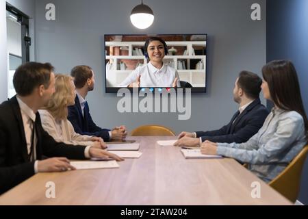 Indische Frau leitet eine Online-Konferenz mit verschiedenen Teamkollegen Stockfoto