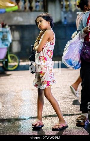 Ein hübsches, junges philippinisches Mädchen wartet auf ihre Familie vor der Kirche Santo Nino de Tondo in Manila auf den Philippinen. Stockfoto