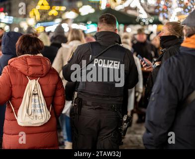 1. Dezember 2023, Hessen, Frankfurt/Main: Polizeibeamte laufen zwischen Besuchern durch den Frankfurter Weihnachtsmarkt auf dem Römerberg. Foto: Frank Rumpenhorst/dpa Stockfoto