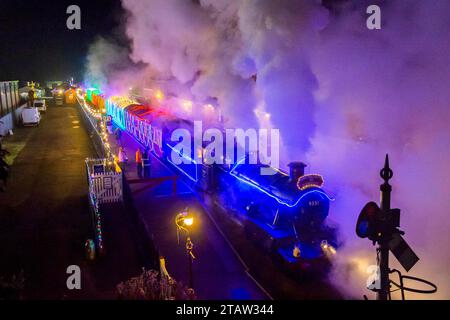 Bischöfe Lydeard, Somerset, Großbritannien. Dezember 2023. Der Winterlights beleuchtete Zug der West Somerset Railway in Somerset verlässt den Bahnhof Bishops Lydeard auf seiner Rückfahrt nach Crowcombe Heathfield. Der Zug fährt jeden Freitag- und Samstagabend bis Neujahr. Bildnachweis: Graham Hunt/Alamy Live News Stockfoto