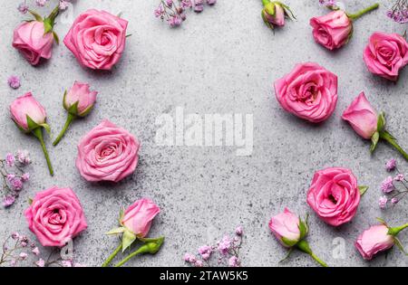 Farbige gypsophila-Blumen und rosa Rosen auf Betonhintergrund mit Kopierraum. Stockfoto