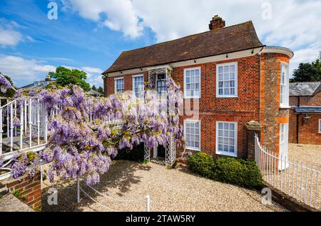 Blick auf Bridge House in der High Street, Hungerford, eine historische Marktstadt in Berkshire, England, mit Glyzinien in der Blüte im Spätherbst bis Frühsommer Stockfoto