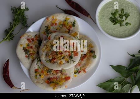 Südindisches Uttapam. Gesunder Pfannenkuchen aus fermentiertem Reis und Linsen. Garniert mit Zwiebeln, Karotten, Koriander und grünen Chilis. Serviert Stockfoto