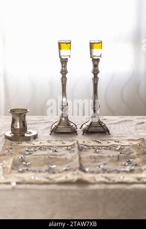 Shabbat-Bild - silberne Kerzenhalter mit Olivenöl, silberner Kiddush-Becher und Challah Stockfoto