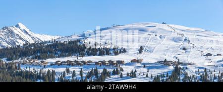 Panoramablick auf Berggipfel mit Liftanlagen in einem Skigebiet in Königsleiten, Österreich, an einem sonnigen Tag. Stockfoto