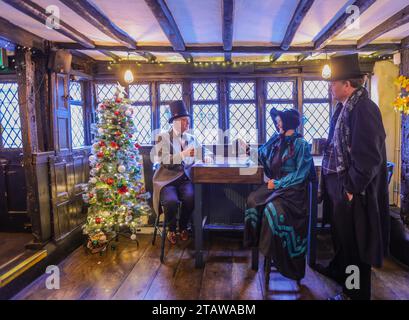 Dorking, Surrey, Großbritannien. Dezember 2023. Menschen in viktorianischer Kleidung im King Arms Pub, erwähnt im Roman Little Dorrit von Charles Dickens, in dem das Weihnachtsfest in Dorking Town Dickensian gefeiert wird. Quelle: Paul Quezada-Neiman/Alamy Live News Stockfoto