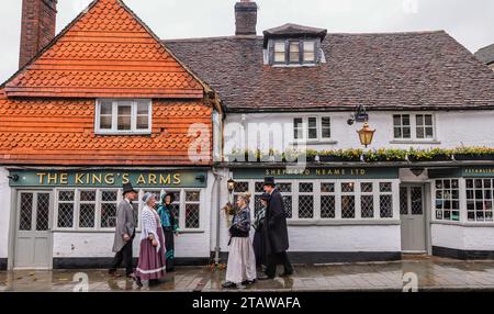 Dorking, Surrey, Großbritannien. Dezember 2023. Menschen in viktorianischer Kleidung im King Arms Pub, erwähnt im Roman Little Dorrit von Charles Dickens, in dem das Weihnachtsfest in Dorking Town Dickensian gefeiert wird. Quelle: Paul Quezada-Neiman/Alamy Live News Stockfoto