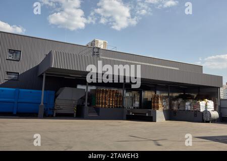 Laderampen eines Lagers. Wellblechlager Industriegebäude vor blauem, klarem Himmel Stockfoto