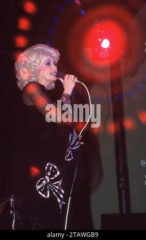 Dolly Parton trat bei einem Konzert während ihrer Sommer-Tour durch den Mittleren Westen 1978 auf. Ein Spezialeffekt-Filter wurde verwendet, um den runden roten Lichteffekt zu erzeugen. Stockfoto