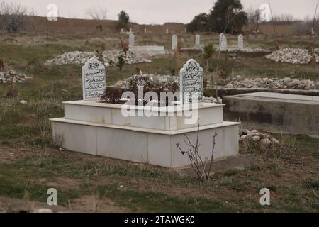 Friedhof in grüner Umgebung, mit einem arabischen Satz auf dem Grab | Foto eines islamischen Grabes. Stockfoto