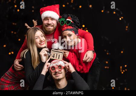 Vier Freunde feiern Silvester und sehen glücklich und fröhlich aus Stockfoto