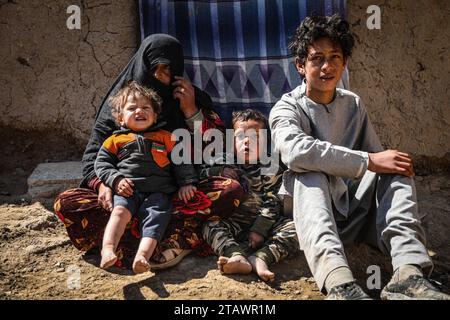 Eine traurige Witwe in Not, begleitet von ihren Kindern, repräsentiert afghanische Familien mit Armut und Not | Flüchtlingsfamilie. Stockfoto