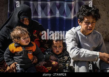 Eine traurige Witwe in Not, begleitet von ihren Kindern, repräsentiert afghanische Familien mit Armut und Not | Flüchtlingsfamilie. Stockfoto