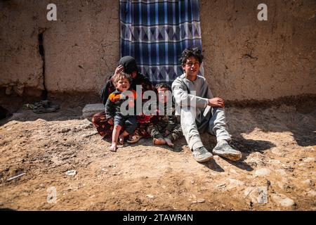 Eine traurige Witwe in Not, begleitet von ihren Kindern, repräsentiert afghanische Familien mit Armut und Not | Flüchtlingsfamilie. Stockfoto