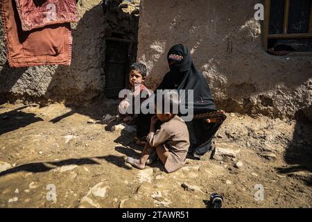 Eine traurige Witwe in Not, begleitet von ihren Kindern, repräsentiert afghanische Familien mit Armut und Not | Flüchtlingsfamilie. Stockfoto