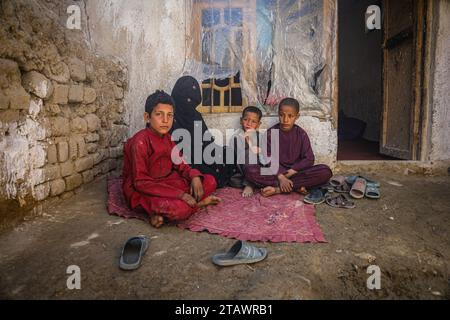 Eine traurige Witwe in Not, begleitet von ihren Kindern, repräsentiert afghanische Familien mit Armut und Not | Flüchtlingsfamilie. Stockfoto