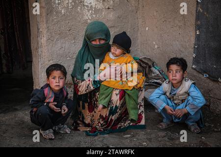 Eine traurige Witwe in Not, begleitet von ihren Kindern, repräsentiert afghanische Familien mit Armut und Not | Flüchtlingsfamilie. Stockfoto