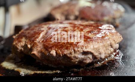 Nahaufnahme von saftigen Burgerpasteten, die auf einem elektrischen Grill gekocht werden. Kochen zu Hause, Küchengerät, gesunde Ernährung, Hamburger Zutaten Stockfoto