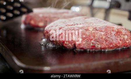 Nahaufnahme von Saft, der aus Hamburger-Patties fließt und kocht. Kochen zu Hause, Küchengerät, gesunde Ernährung, Hamburger Zutaten Stockfoto