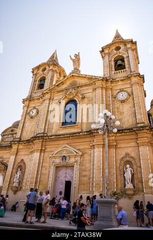 Zurrieq, Malta - 18. Juni 2023: Fassade der Pfarrkirche St. Katharina im Dorf Zurrieq mit Gläubigen nach der Messe Stockfoto