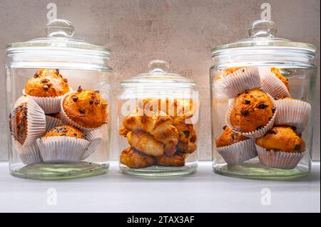 Beked-Muffins und Croissants schlagen Schokolade im Glas Stockfoto