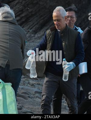 Tsushima, Japan. Dezember 2023. Der US-Botschafter in Japan Rahm Emanuel sammelt während der Strandreinigung am Strand von Kujika in Tsushima, Präfektur Nagasaki, Japan am Sonntag, den 3. Dezember 2023 Plastikmüll auf. Foto: Keizo Mori/UPI Credit: UPI/Alamy Live News Stockfoto