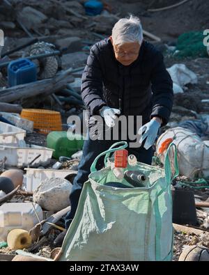 Tsushima, Japan. Dezember 2023. Der südkoreanische Botschafter in Japan Yun Duk-min sammelt Plastikmüll während der Strandreinigung am Strand Kujika in Tsushima, Präfektur Nagasaki, Japan am Sonntag, den 3. Dezember 2023. Foto: Keizo Mori/UPI Credit: UPI/Alamy Live News Stockfoto