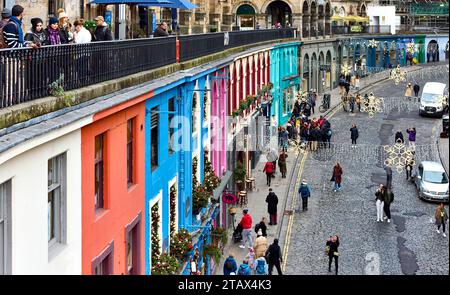 Edinburgh Scotland Victoria Street mit Blick auf eine Reihe von bunten Häusern, eine Kopfsteinpflasterstraße und viele Besucher im frühen Winter Stockfoto