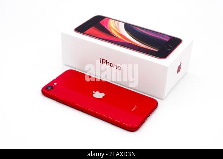 Apple iPhone SE Second Edition neben der Box mit weißem Hintergrund. „Rotes Produkt“ – Verkauf an den Globalen Fonds zur Bekämpfung von COVID-19. Stockfoto