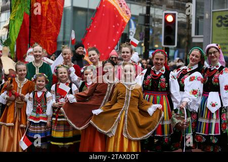 Manchester, Großbritannien. Dezember 2023. Die Manchester Christmas Parade ist auf dem Weg durch die Straßen der Stadt, mit all den üblichen Charakteren wie dem Weihnachtsmann und den echten Elfen. Eine Pipe Band und Trommelgruppe Salva liefern einige der Klänge mit Familien entlang der Straßen, um einen Blick auf einige der riesigen Marionetten und die lebensgroße Kugel mit Snow Queen zu werfen. Manchester, Großbritannien. Stockfoto