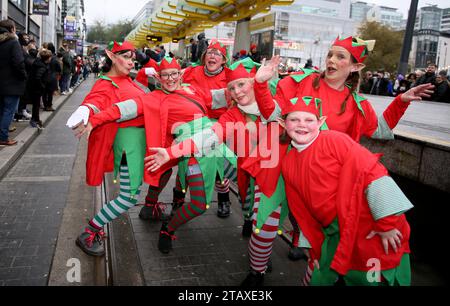 Manchester, Großbritannien. Dezember 2023. Die Manchester Christmas Parade ist auf dem Weg durch die Straßen der Stadt, mit all den üblichen Charakteren wie dem Weihnachtsmann und den echten Elfen. Eine Pipe Band und Trommelgruppe Salva liefern einige der Klänge mit Familien entlang der Straßen, um einen Blick auf einige der riesigen Marionetten und die lebensgroße Kugel mit Snow Queen zu werfen. Manchester, Großbritannien. Stockfoto