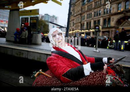 Manchester, Großbritannien. Dezember 2023. Die Manchester Christmas Parade ist auf dem Weg durch die Straßen der Stadt, mit all den üblichen Charakteren wie dem Weihnachtsmann und den echten Elfen. Eine Pipe Band und Trommelgruppe Salva liefern einige der Klänge mit Familien entlang der Straßen, um einen Blick auf einige der riesigen Marionetten und die lebensgroße Kugel mit Snow Queen zu werfen. Manchester, Großbritannien. Stockfoto