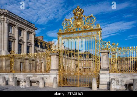 Goldene Eingangstoren des Chateau de Versailles mit untergehender Sonneneinstrahlung, Frankreich - 27. Juli 2022 Stockfoto