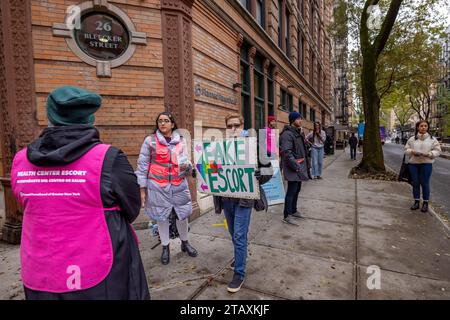 NEW YORK, NEW YORK - 2. DEZEMBER: Ein Aktivist für Abtreibungsrechte hält ein „Fake Escort“-Schild neben einem Anti-Abtreibung-Befürworter, der sich als geplanter Elternschaft-Mitarbeiter ausgibt, um Patienten von einer Versorgung abzuhalten, die am 2. Dezember 2023 in New York City stattfindet. (Foto: Michael Nigro/SIPA USA) Credit: SIPA USA/Alamy Live News Stockfoto