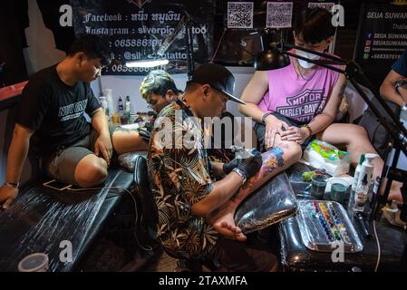 Bangkok, Thailand. Dezember 2023. Tätowierer machen Tattoos für Teilnehmer während der Land of Ink Bangkok Tattoo Convention 2023 im ChangChui Creative Park in Bangkok. Hunderte von nationalen und internationalen Tätowierkünstlern und -Enthusiasten nehmen an der Land of Ink Bangkok Tattoo Convention 2023 Teil, um ihre Designfähigkeiten in einem Tätowierwettbewerb unter Beweis zu stellen. Quelle: SOPA Images Limited/Alamy Live News Stockfoto