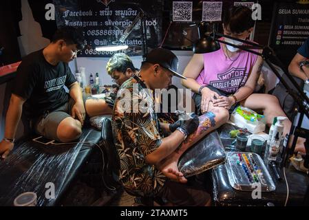 Bangkok, Thailand. Dezember 2023. Tätowierer machen Tattoos für Teilnehmer während der Land of Ink Bangkok Tattoo Convention 2023 im ChangChui Creative Park in Bangkok. Hunderte von nationalen und internationalen Tätowierkünstlern und -Enthusiasten nehmen an der Land of Ink Bangkok Tattoo Convention 2023 Teil, um ihre Designfähigkeiten in einem Tätowierwettbewerb unter Beweis zu stellen. (Foto: Peerapon Boonyakiat/SOPA Images/SIPA USA) Credit: SIPA USA/Alamy Live News Stockfoto