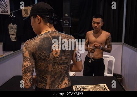 Bangkok, Thailand. Dezember 2023. Ein Teilnehmer bereitet sich darauf vor, sein Tattoo während der Land of Ink Bangkok Tattoo Convention 2023 im ChangChui Creative Park in Bangkok zu präsentieren. Hunderte von nationalen und internationalen Tätowierkünstlern und -Enthusiasten nehmen an der Land of Ink Bangkok Tattoo Convention 2023 Teil, um ihre Designfähigkeiten in einem Tätowierwettbewerb unter Beweis zu stellen. (Foto: Peerapon Boonyakiat/SOPA Images/SIPA USA) Credit: SIPA USA/Alamy Live News Stockfoto