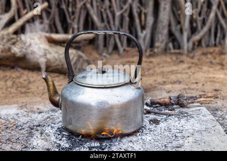 Aluminium-Teekanne auf offenem Feuer in der Außenküche, afrikanisches Dorf Stockfoto