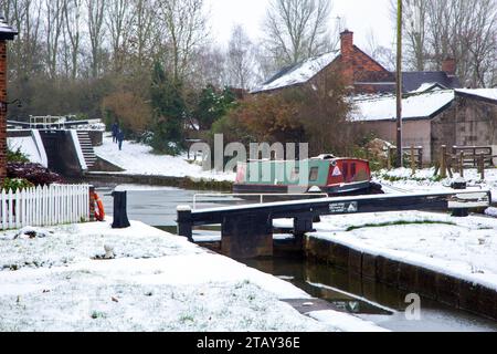 Canal Schmalboot vertäut im Winter auf dem Trent and Mersey Kanal im Schnee bei den Wheelock Schleusen Cheshire England UK Stockfoto