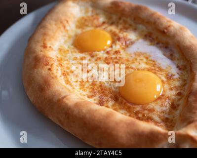 Bootförmige adjarische Khachapuri auf dem Teller, selektiver Fokus. Traditionelle georgische Küche Stockfoto