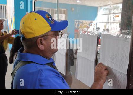 Maracaibo-Venezuela-03-12-2023- Ein Wähler sucht nach seiner ID-Nummer, um am zugewiesenen Tisch zu wählen. Geringe Teilnahme an Wahlzentren. Stockfoto