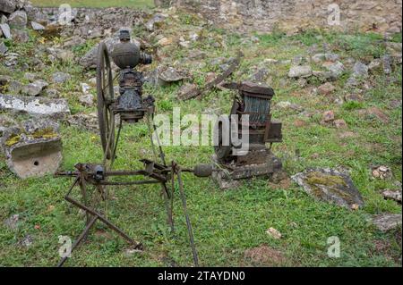 Details von zwei alten Maschinen aus einer Fabrik, sie sind rostig und stehen im abgerissenen Gebäude und voller Vegetation Stockfoto