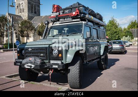 Vorderansicht eines schönen grünen englischen Land Rover Defender SUV, ausgestattet für Abenteuer mit dem Dachträger voller Werkzeuge und Zubehör Stockfoto