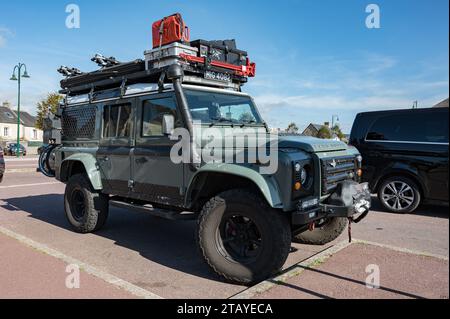 Vorderansicht eines schönen grünen englischen Land Rover Defender SUV, ausgestattet für Abenteuer mit dem Dachträger voller Werkzeuge und Zubehör Stockfoto